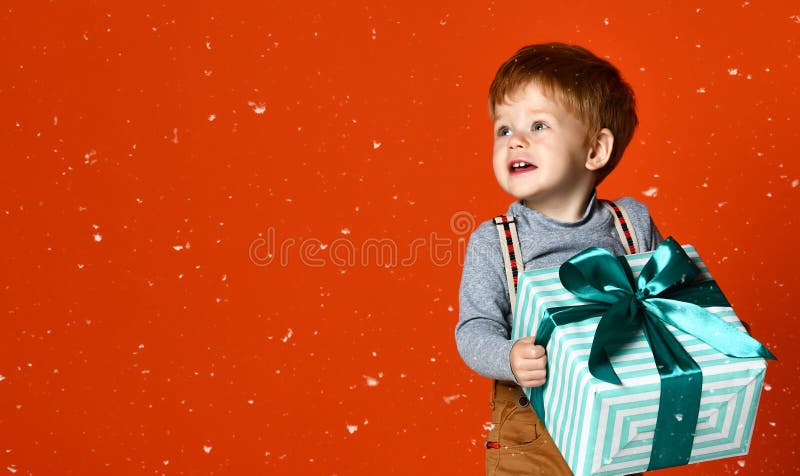 Pequeño muchacho divertido con el regalo foto de archivo libre de regalías Pequeño muchacho divertido con el regalo foto de archivo libre de regalías