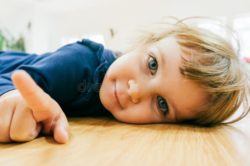 Pequeño niño en el piso imagen de archivo Pequeño niño en el piso imagen de archivo