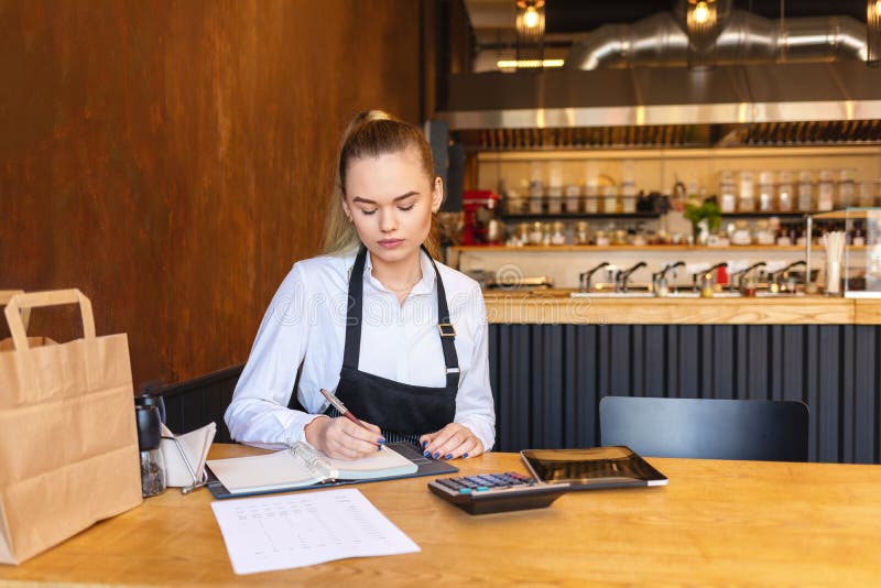 Pequeño propietario de restaurante de la familia que hace las finanzas que calculan cuentas y costos de la pequeña empresa imagenes de archivo Pequeño propietario de restaurante de la familia que hace las finanzas que calculan cuentas y costos de la pequeña empresa imagenes de archivo