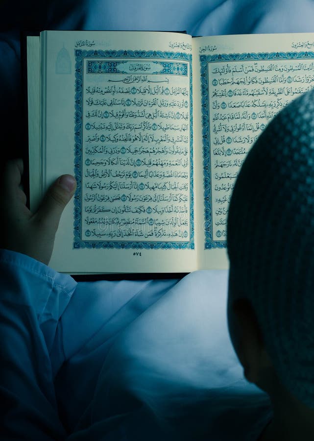 Pequeño Quran musulmán de la lectura del niño en la noche del Ramadán fotografía de archivo Pequeño Quran musulmán de la lectura del niño en la noche del Ramadán fotografía de archivo