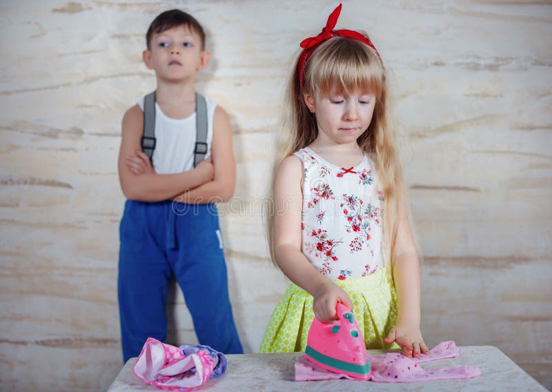 Pequeños niños serios que juegan la casa imagen de archivo