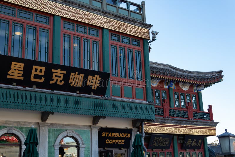 PEQUIM, CHINA - 19 DE DEZEMBRO DE 2017: Cafetaria de Starbucks na construção chinesa do estilo tradicional na rua de Qianmen no P fotos de stock PEQUIM, CHINA - 19 DE DEZEMBRO DE 2017: Cafetaria de Starbucks na construção chinesa do estilo tradicional na rua de Qianmen no P fotos de stock