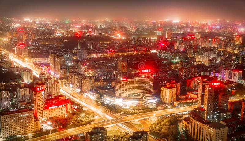 PEQUIM - CHINA, EM MAIO DE 2016: Cidade na noite em que os arranha-céus altos são iluminados imagem de stock PEQUIM - CHINA, EM MAIO DE 2016: Cidade na noite em que os arranha-céus altos são iluminados imagem de stock