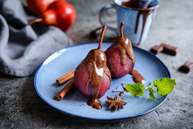 Peras escalfadas en vino rojo y rematadas con la salsa de chocolate imágenes de archivo libres de regalías Peras escalfadas en vino rojo y rematadas con la salsa de chocolate imágenes de archivo libres de regalías