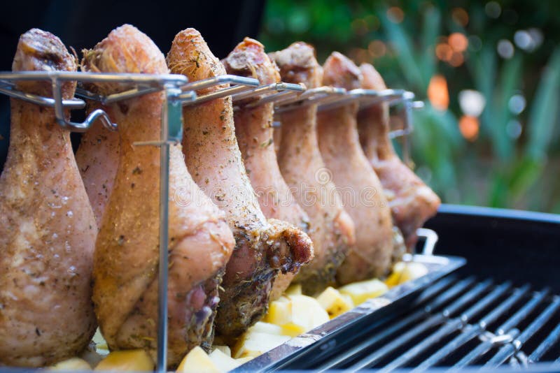 Perda su delle bacchette di pollo coperte condendo nella griglia prima della torrefazione fotografie stock Perda su delle bacchette di pollo coperte condendo nella griglia prima della torrefazione fotografie stock