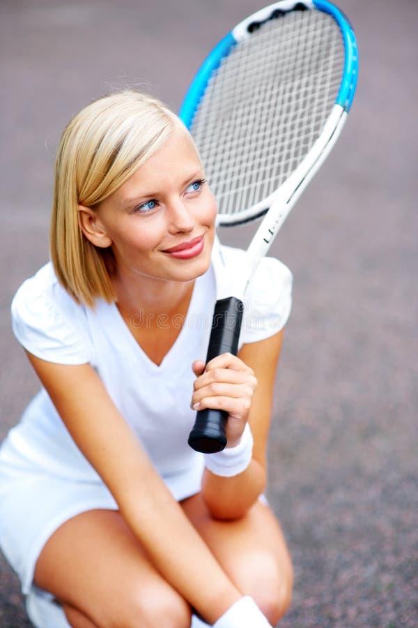 Perdu dans un rêve de victoire. un jeune joueur de tennis s'agenouille et rêve de gagner son match. photo stock