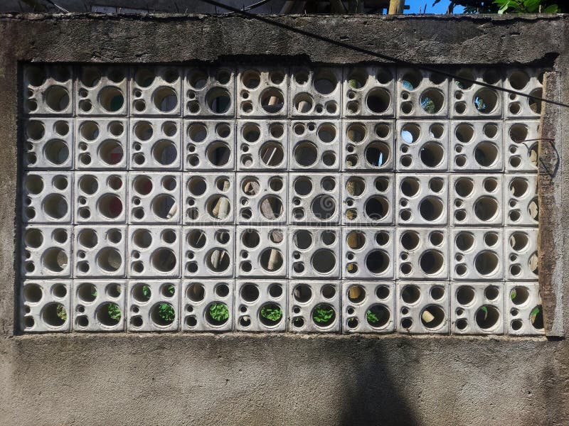 Perete de ventilație de ciment cu găuri circulare artistice care creează modele geometrice stock photography