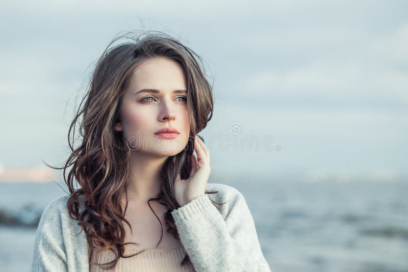 Perfect girl outdoors against sea and sky, romantic portrait.