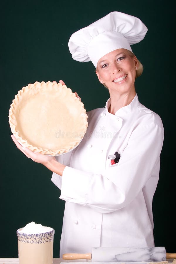 Assertive pose of a proud uniformed female Chef holding up her formed pie crust. Assertive pose of a proud uniformed female Chef holding up her formed pie crust.