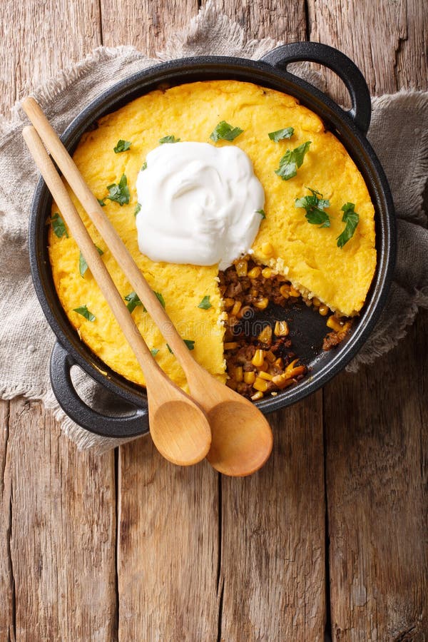 Perfect Tamale Pie Recipe - Rich zesty beef filling topped with fluffy corn bread closeup. Vertical top view