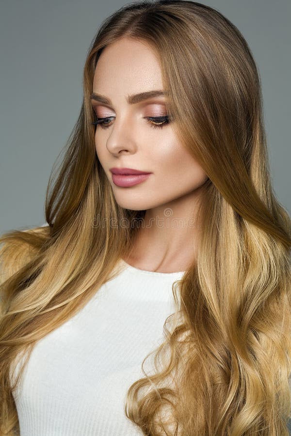 Perfect woman with thick blonde hair and white blouse over grey background. royalty free stock photo Perfect woman with thick blonde hair and white blouse over grey background. royalty free stock photo