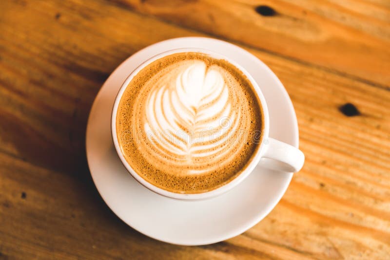 Perfecte cappuccino in witte kop op houten lijst royalty-vrije stock afbeelding Perfecte cappuccino in witte kop op houten lijst royalty-vrije stock afbeelding