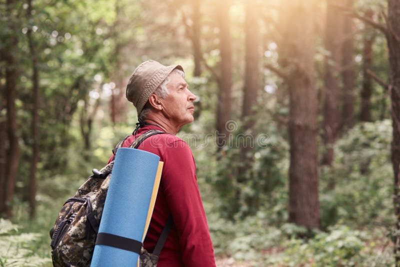 Perfil del hombre mayor que mira a un lado atento, el acampar que va, vagando en bosque, uniendo con la naturaleza, teniendo moch fotos de archivo Perfil del hombre mayor que mira a un lado atento, el acampar que va, vagando en bosque, uniendo con la naturaleza, teniendo moch fotos de archivo