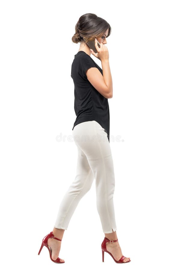 Perfile a opinião o empregado de mulher ocupado do negócio que anda e que fala no telefone que olha para baixo imagens de stock royalty free Perfile a opinião o empregado de mulher ocupado do negócio que anda e que fala no telefone que olha para baixo imagens de stock royalty free