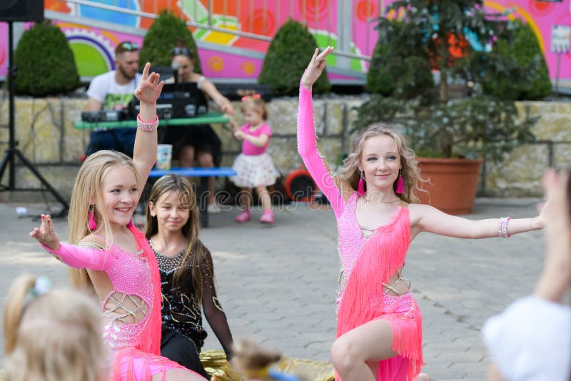 Performance of young dancers. A group of young dancers in public. Dancing in the open air. Rising young dancers. The kids dance school, ballet, hiphop, street, funky and modern dancers on gray studio background. Sublings day.