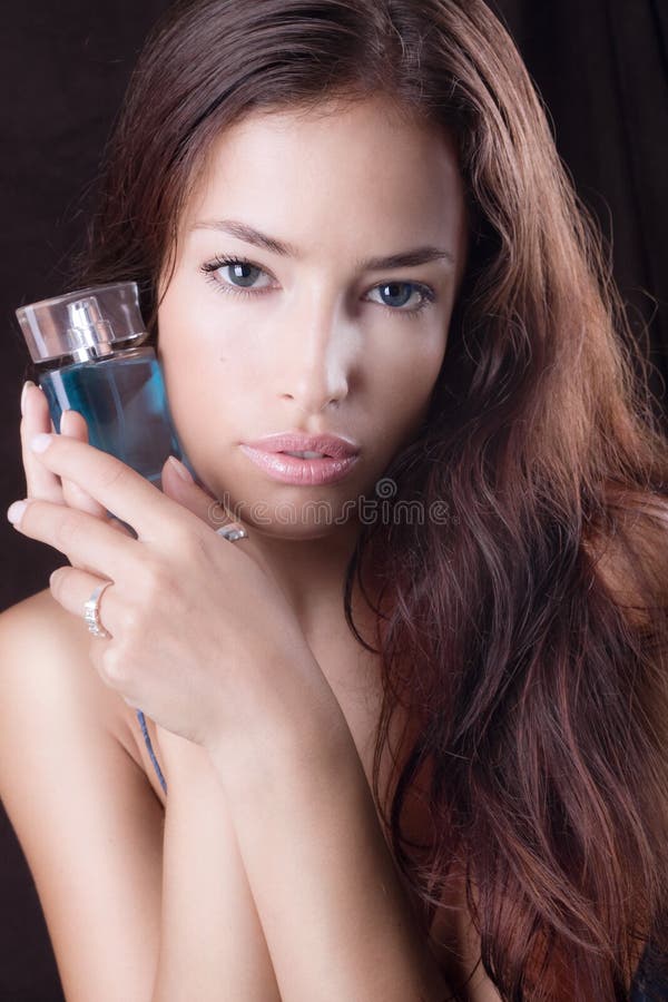 Beautiful woman with bottle of perfume