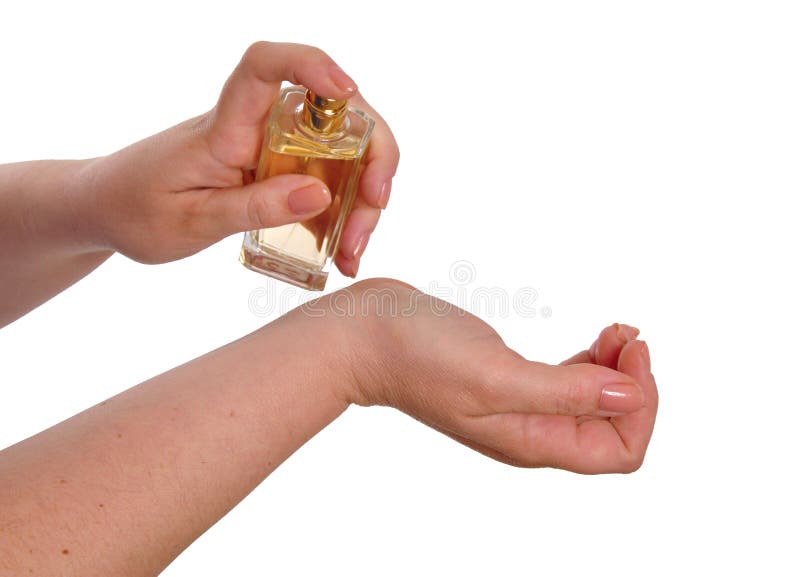 Woman spraying perfume on her wrist against a white background