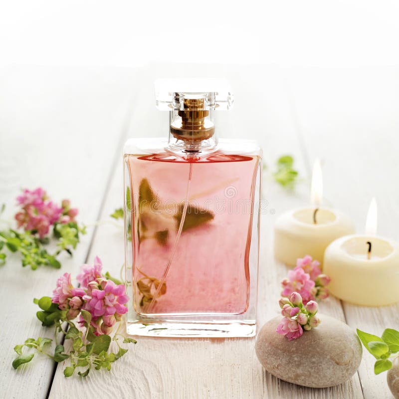 Perfume, Candles and Flowers on a Blurred Green Background. Spa Concept