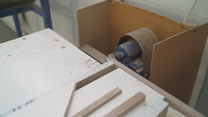 Perfuração de um buraco numa peça de trabalho. um homem fura numa peça de trabalho com furadeira. fabricação de mobiliário.