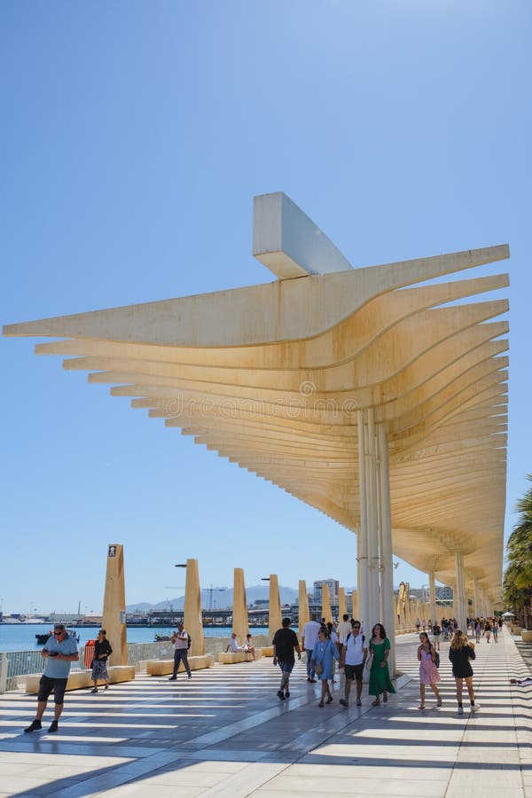 Malaga, Spain - May 26, 2022: Pergolas de la Victoria in Malaga, Spain, with many people walking under them to protect themselves from the strong sunrays of a hot spring day. Malaga, Spain - May 26, 2022: Pergolas de la Victoria in Malaga, Spain, with many people walking under them to protect themselves from the strong sunrays of a hot spring day