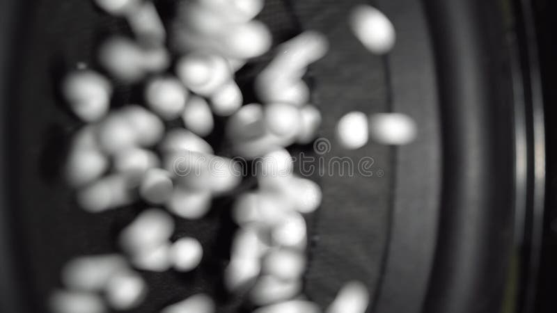 Perles de polystyrène sautant sur une surface fonctionnante de haut-parleur banque de vidéos