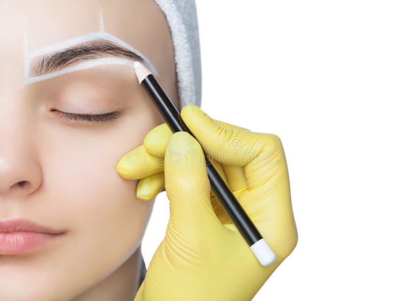 Permanent make-up for eyebrows of beautiful woman with thick brows in beauty salon.