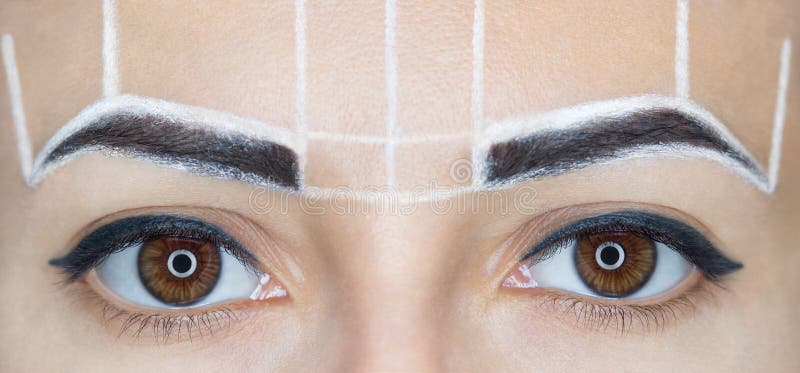 Permanent make-up for eyebrows of beautiful woman with thick brows in beauty salon.