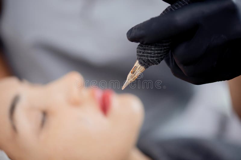 Permanent make-up of lips, eyebrows and eyes, woman on tattoo procedure