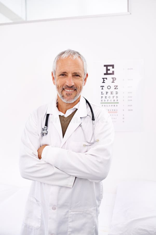 Permette di mettere gli occhi al test. ritratto di un adulto optometrista maschio in piedi nel suo ufficio con una cartina dell'oc fotografia stock