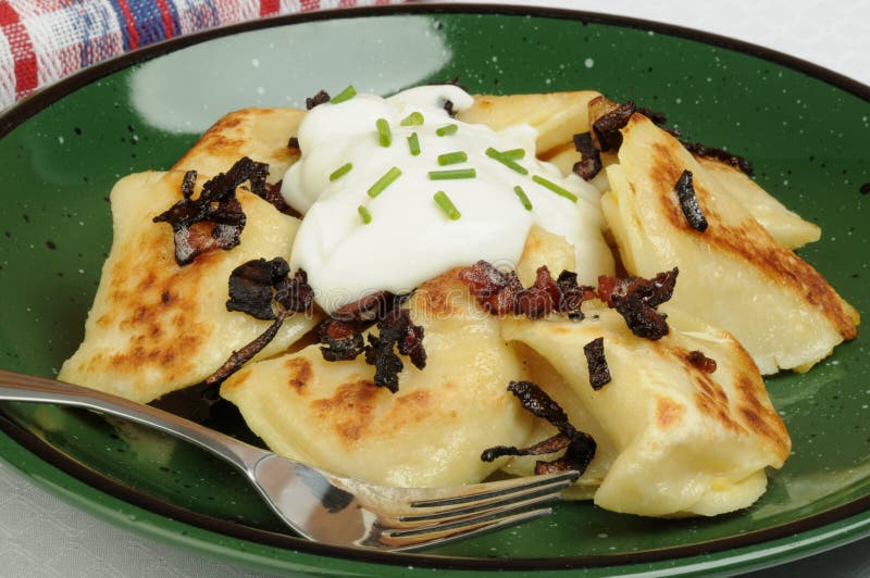 Plate of delicious homemade perogies and sour cream. Plate of delicious homemade perogies and sour cream.