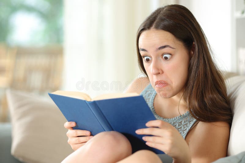 Perplexed woman reading a paper book in a house royalty free stock photo