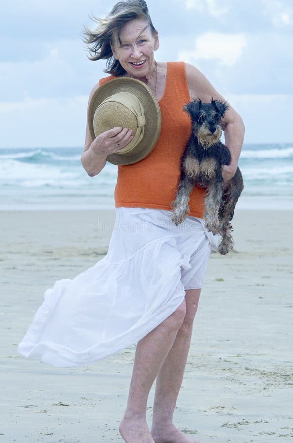 Perro de perrito del animal doméstico de la mujer que lleva mayor en la playa para el día hacia fuera fotografía de archivo libre de regalías Perro de perrito del animal doméstico de la mujer que lleva mayor en la playa para el día hacia fuera fotografía de archivo libre de regalías