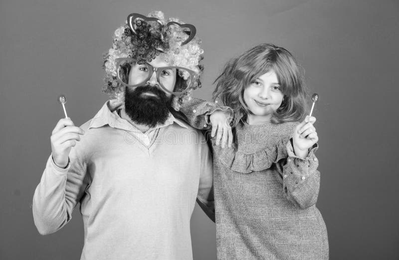 Perruque color?e barbue d'usage de p?re et de fille d'homme tandis que mangez la sucrerie de lucette P?re aimant de chose faire p image stock Perruque color?e barbue d'usage de p?re et de fille d'homme tandis que mangez la sucrerie de lucette P?re aimant de chose faire p image stock