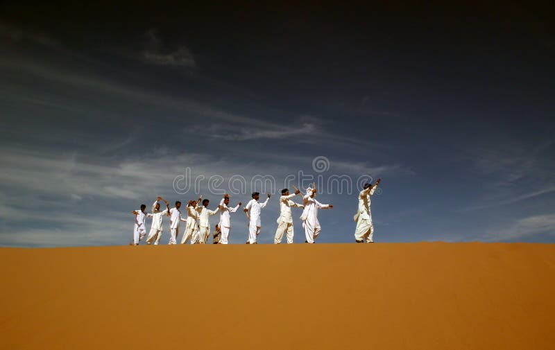 Persian ethnic dancers on sand dune in a festival in Eastern Iran