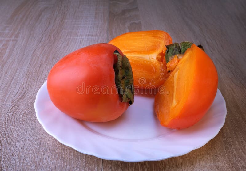 Persimmon-vruchten sluiten rijpe vruchten op een plaat