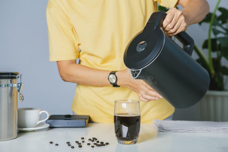 Persoane care utilizează ceainicul turnând apă caldă, făcând cafea cu gheață sau cafea americană rece în cană cu echipament digita royalty free stock photos