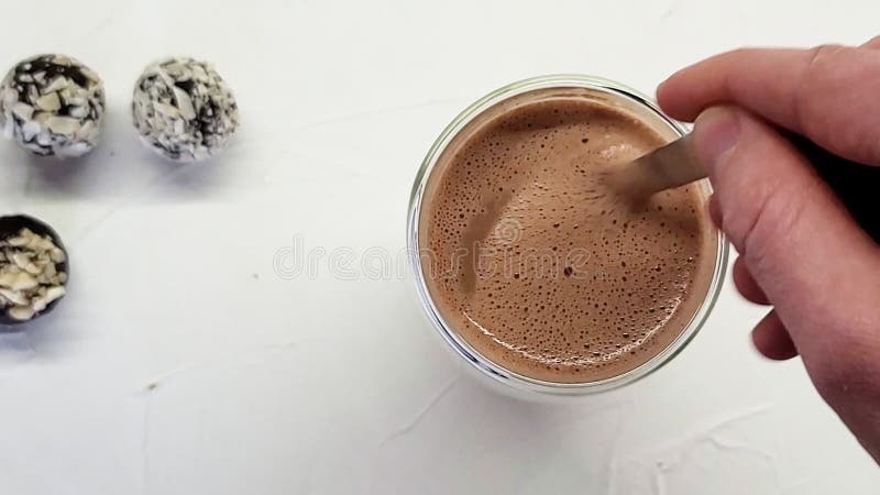 Persoană care amestecă manual paharul cu ciocolată caldă. cafea proaspătă de dimineață aproape. mișcare lentă. ciocolată caldă din stock video footage