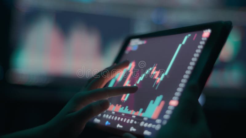 Person analyzing stock market graph on a tablet touchscreen