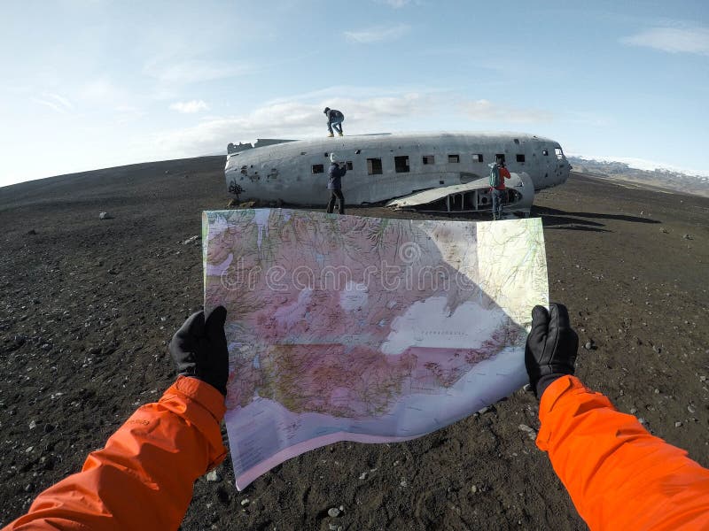 A Person With Black Gloves Holding A Map On The Background Of An Old Plane Under A Clear Sky