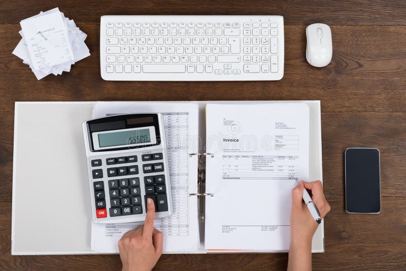 Person Calculating Invoice With Calculator stock photo