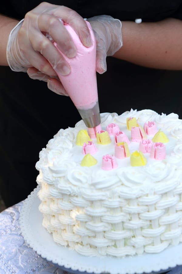 Person decorating cake in a pastry shop