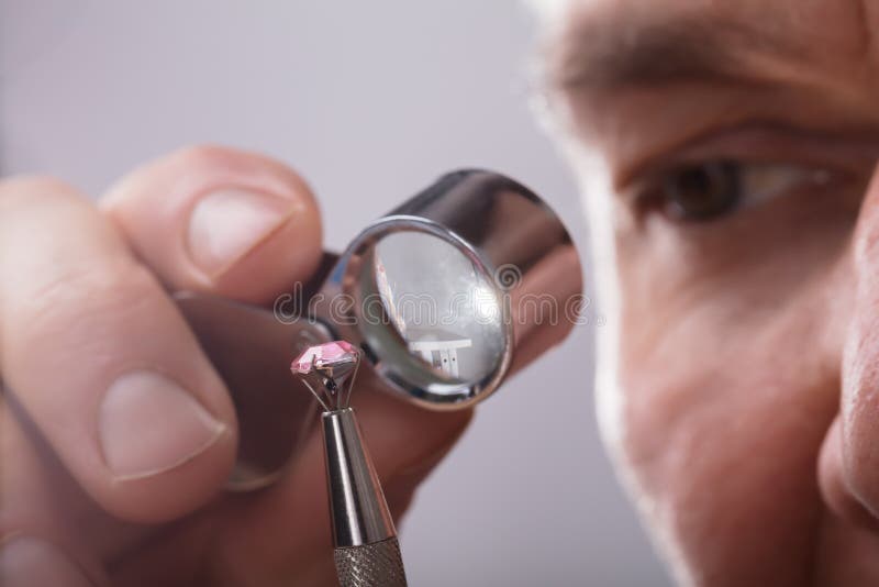 Person, die Diamond Through Magnifying Loupe überprüft lizenzfreie stockbilder Person, die Diamond Through Magnifying Loupe überprüft lizenzfreie stockbilder