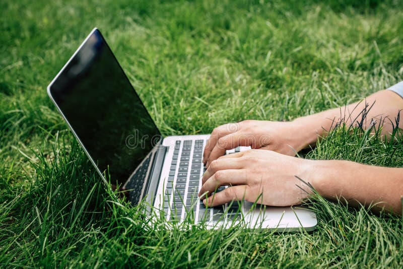 Person, die draußen auf Laptop mit leerem Bildschirm schreibt lizenzfreie stockfotos Person, die draußen auf Laptop mit leerem Bildschirm schreibt lizenzfreie stockfotos