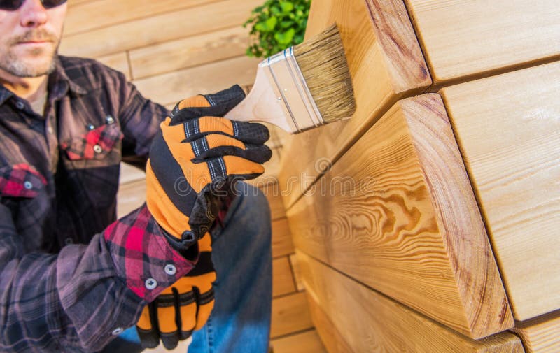 Person, die Holz auf eine glatte Holzfläche während des Projekts zur Wohnungsverbesserung anwenden stockfotografie