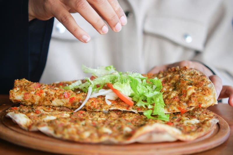 Person enjoying a turkish lahmacun royalty free stock photo