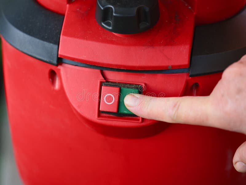 Person finger pressing the green On button on a red machine control panel royalty free stock images