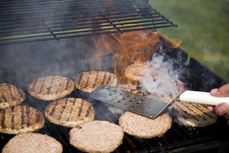 Person Flipping Burgers During BBQ