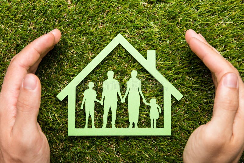 High Angle View Of Person Holding Protective Hand On Family Home At Grass. High Angle View Of Person Holding Protective Hand On Family Home At Grass