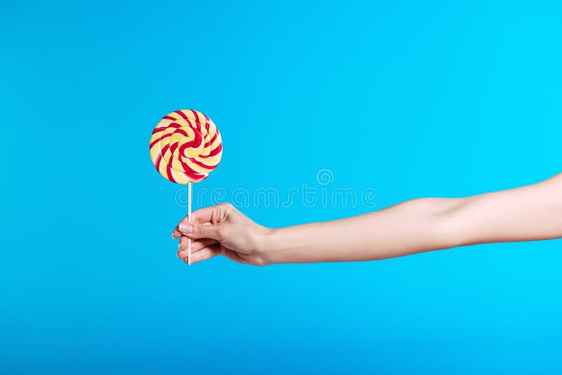 Person Holding Bright Lollipop Isolated on Blue Stock Photo - Image of ...