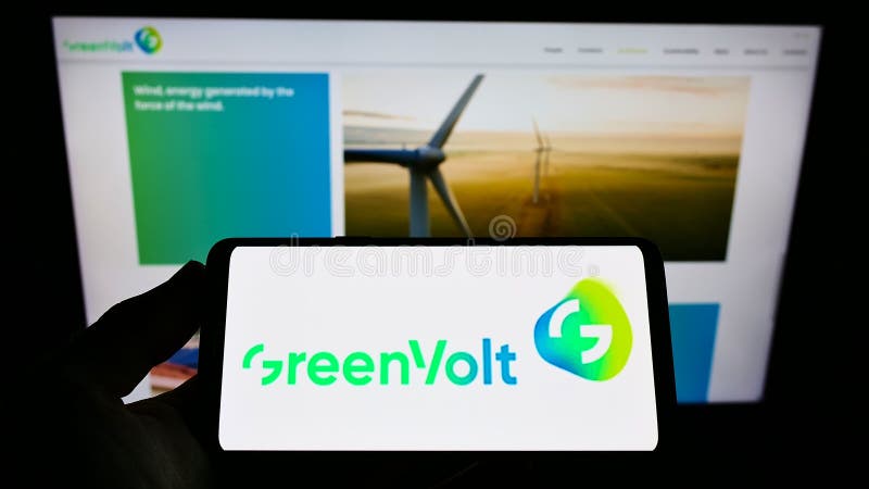 Person holding cellphone with logo of energy company Greenvolt Energias Renováveis SA on screen in front of business webpage. Person holding cellphone with